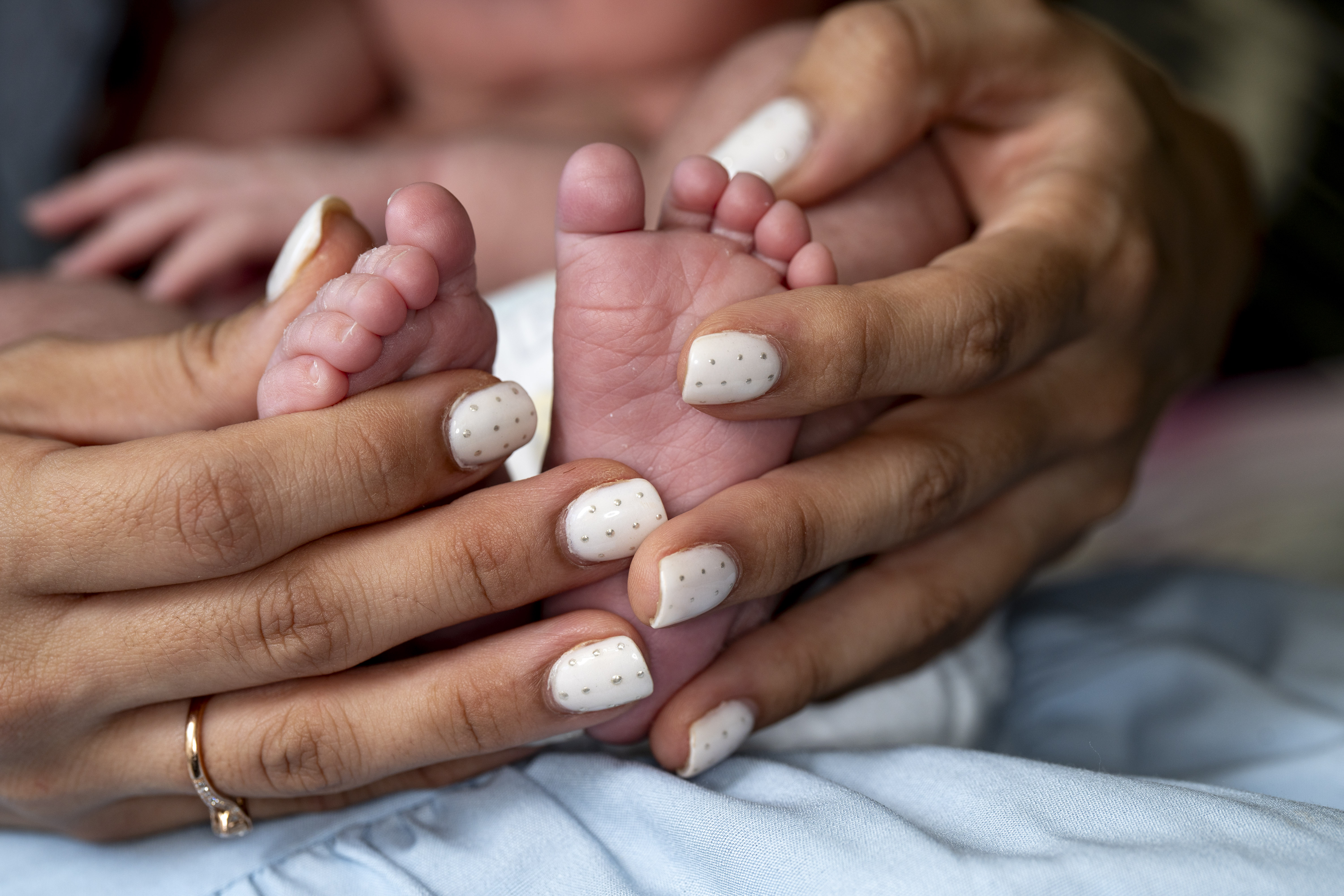 A baby's feet being held by an adult's hands.