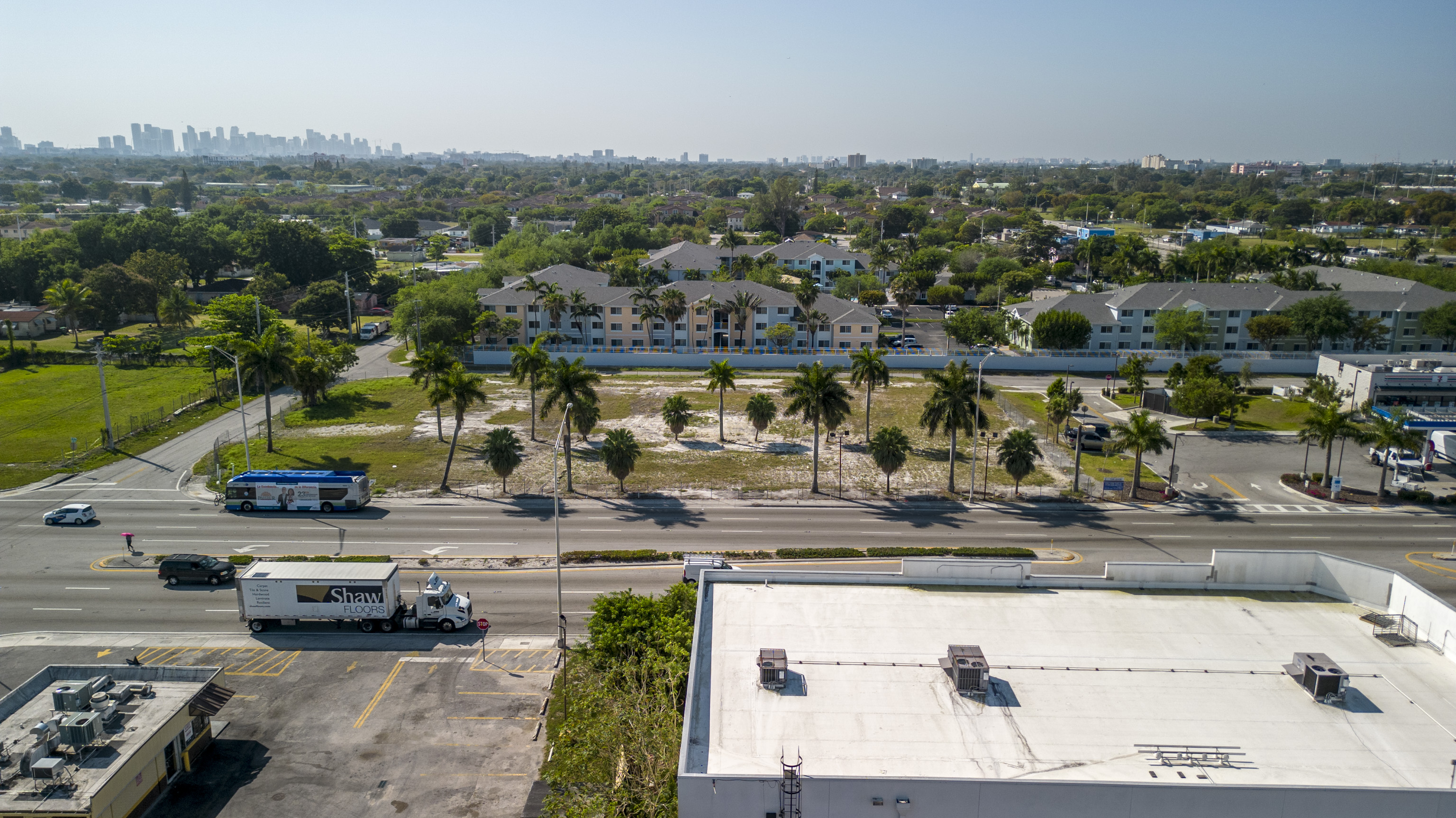 Aerial view of a suburban neighborhood with palm trees and a mix of residential and commercial buildings.